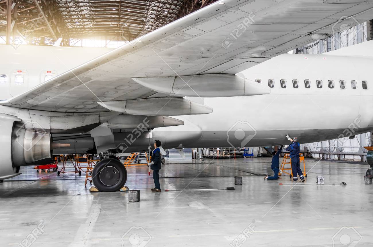 93023737 diverse persone lavano l aereo nell hangar per manutenzione vista del telaio ala e coda Avvitatori per assemblaggio industriale